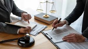 Lawyers reviewing legal documents at a desk with a gavel and justice scales—symbolizing complex securities and torts law challenges in New York City.